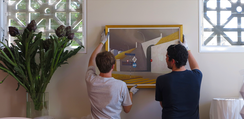 Two People Hanging a Painting