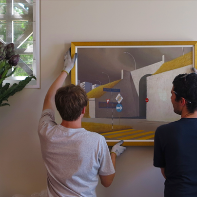 Two People Hanging a Painting